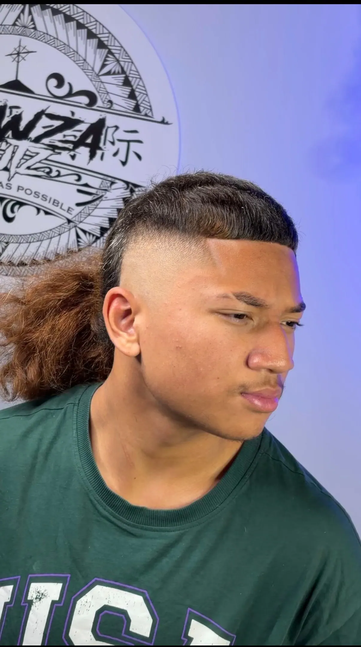 Comb-over cut over a high skin fade, with long curled mullet length left through the back.
