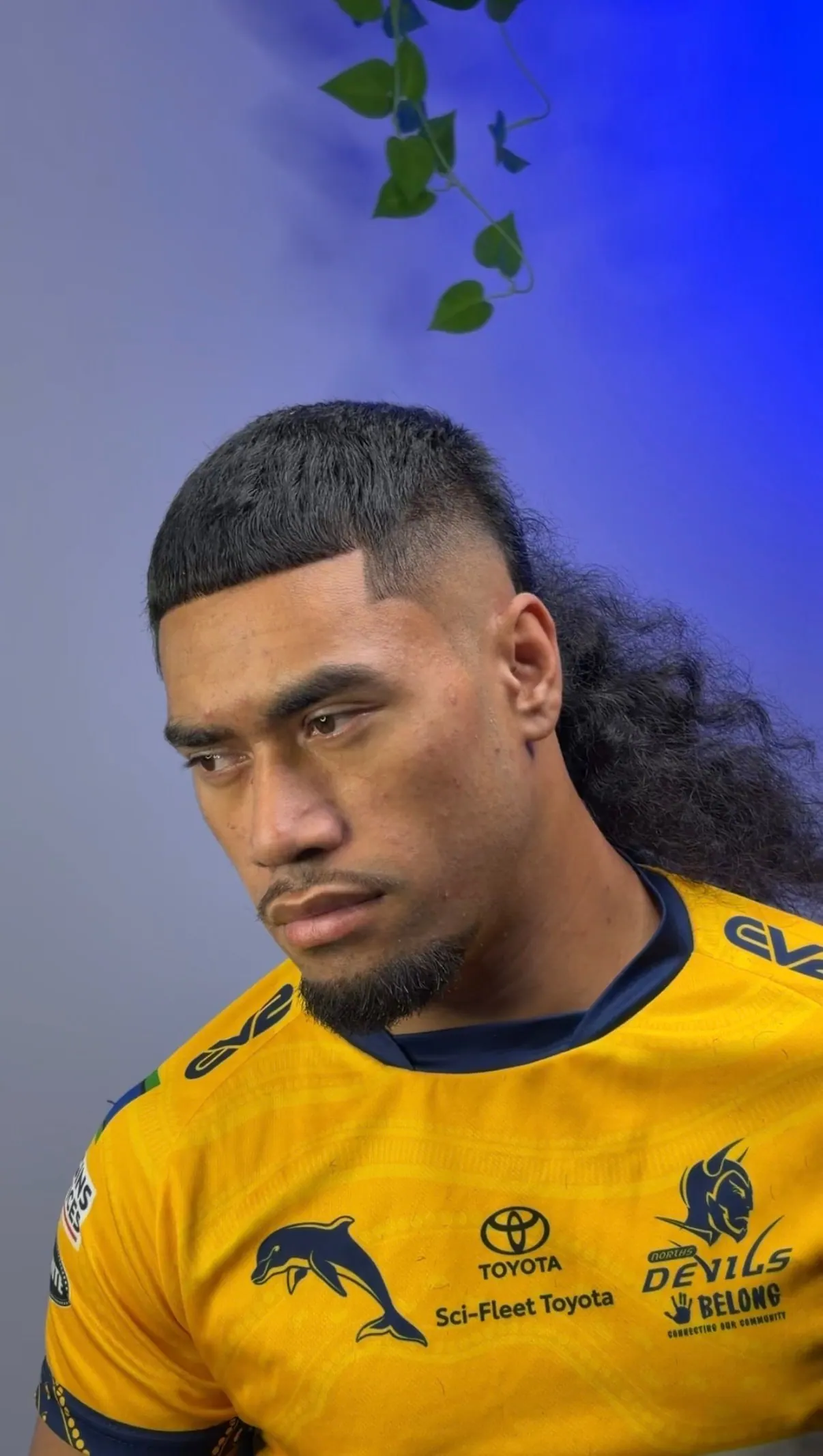 Square flat top with a high skin fade and long curled mullet length through the back.